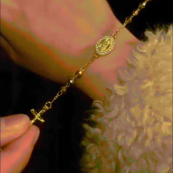 La pulsera Rosario Tres Oros con su medalla de la Virgen y el crucifijo sobre la muñeca