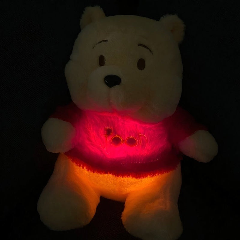 El Pooh a oscuras con la luz cálida y roja encendida en la pancita